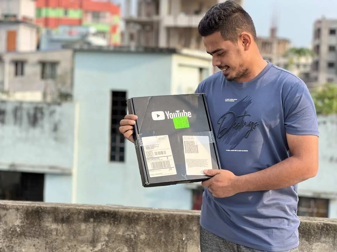 Saif holding his YouTube Silver Play Button